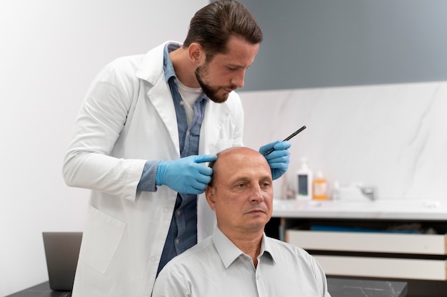 Volwassen man die door een extractieproces van de folliculaire eenheid gaat