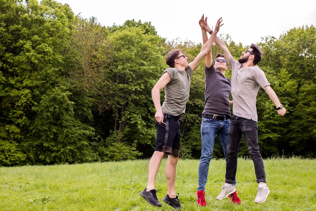 Gratis foto volwassen mannen springen en geven high five