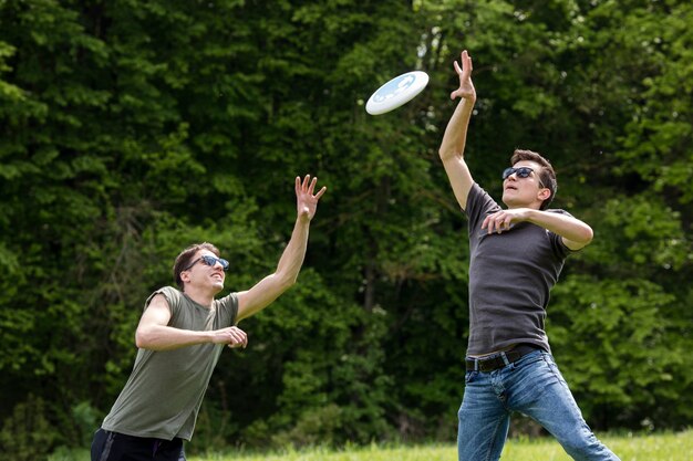 Volwassen mannen springen hoog voor het vangen van frisbee