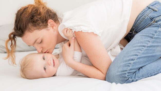 Volwassen moeder die haar babymeisje kust