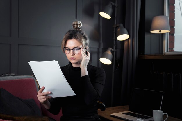 Volwassen onderneemster die documenten onderzoekt