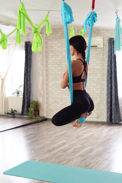 Volwassen vrouw beoefent anti-zwaartekracht yoga