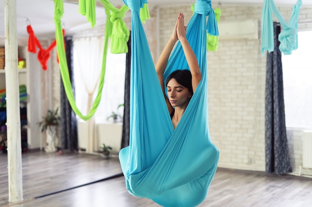 Volwassen vrouw beoefent anti-zwaartekracht yoga