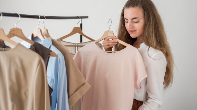 Volwassen vrouw die nieuwe kleren controleert