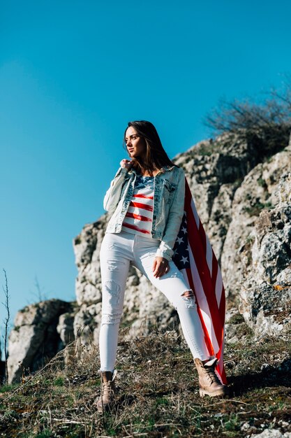 Volwassen vrouw met Amerikaanse vlag in de natuur