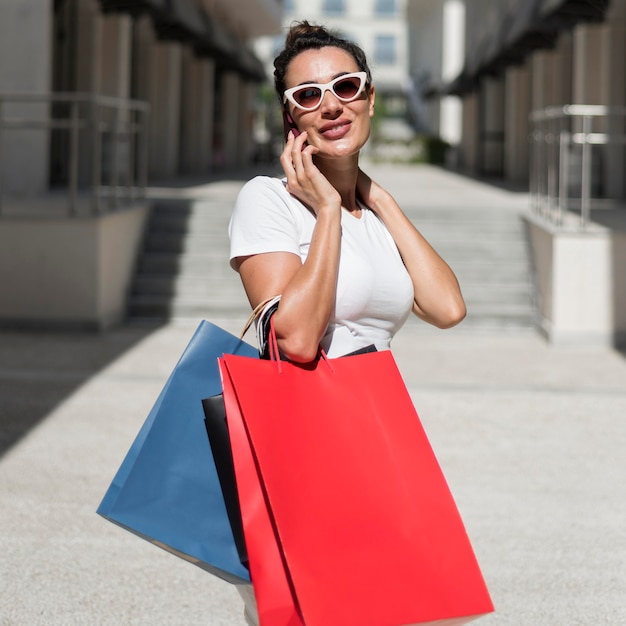 Volwassen vrouw poseren met boodschappentassen