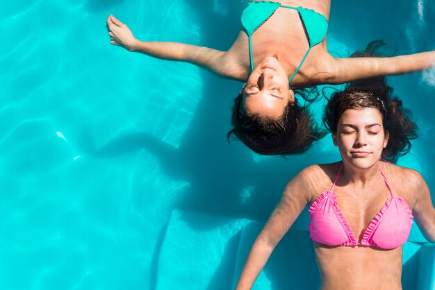 Volwassen vrouwen met gesloten ogen die in pool koelen