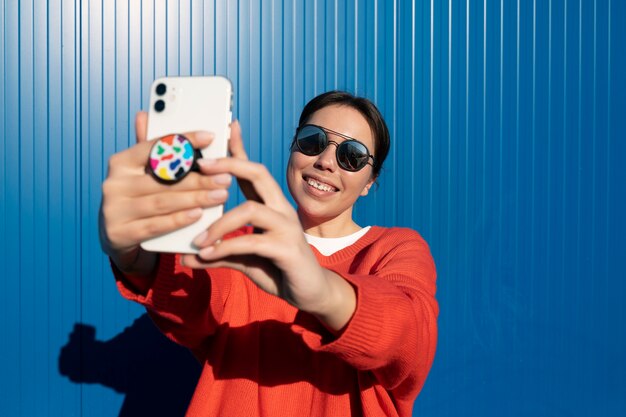 Volwassene die een pop-socket op de telefoon gebruikt