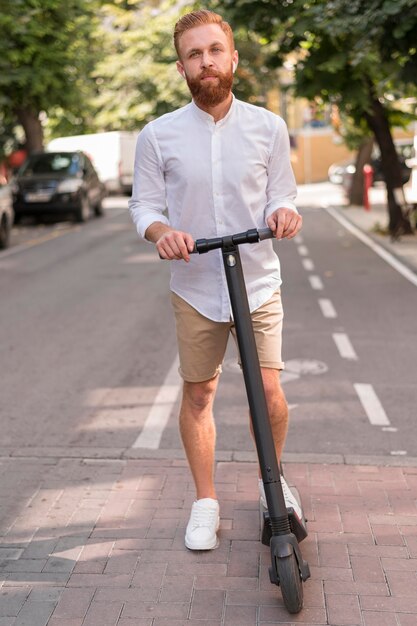 Vooraanzicht bebaarde moderne man op scooter