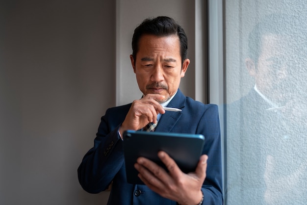 Vooraanzicht bedrijfsmens die aan ipad werkt