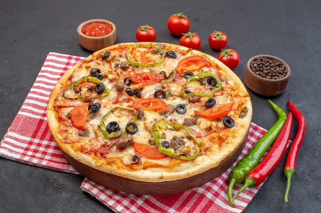 Vooraanzicht bestaat de heerlijke kaaspizza uit olijvenpeper en tomaten op donkere oppervlakte