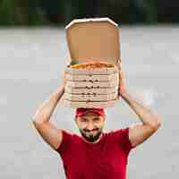 Gratis foto vooraanzicht bezorger met pizzadozen op zijn hoofd