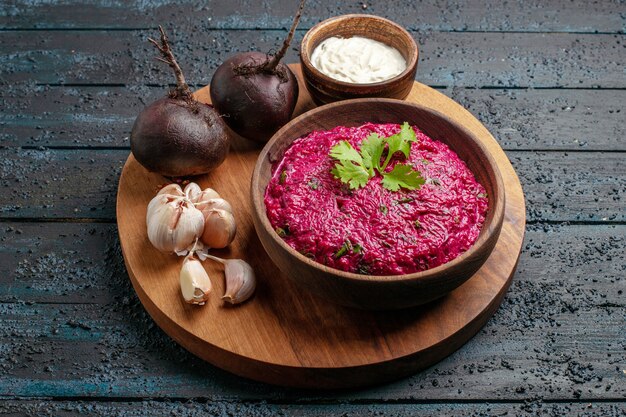 Vooraanzicht bietensalade met zure room en knoflook op donker bureau