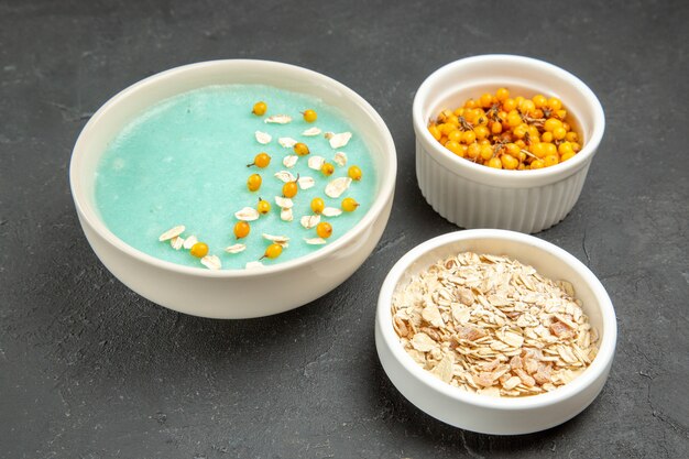 Vooraanzicht blauw ijsdessert met rauwe muesli op het donkere ijsontbijt van de lijstroom