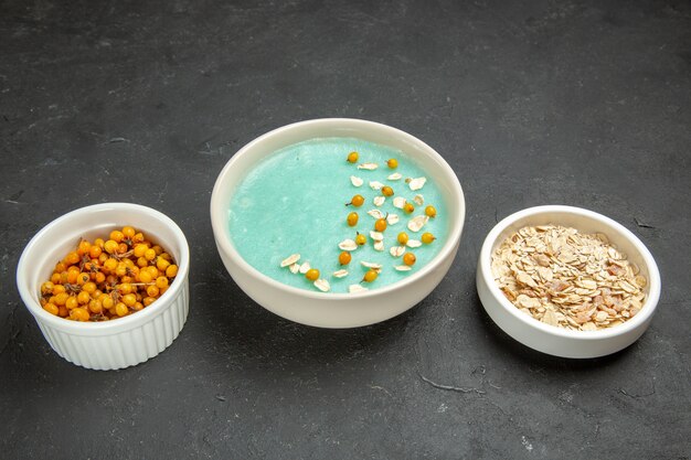 Vooraanzicht blauw ijsdessert met rauwe muesli op het donkere ijsontbijt van de lijstroom