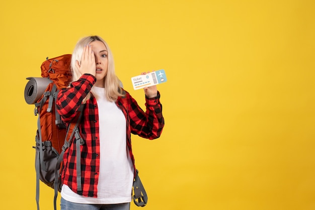 Vooraanzicht blond meisje met haar rugzak met kaartje hand op haar oog te zetten