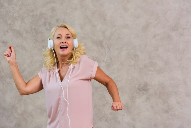 Vooraanzicht blonde dame luisteren naar muziek op koptelefoon set