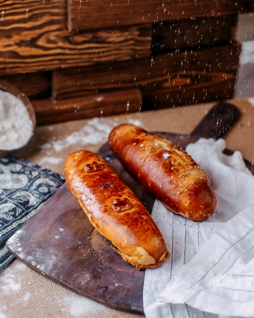 Vooraanzicht brood bruin met meel gegoten op het bruine oppervlak