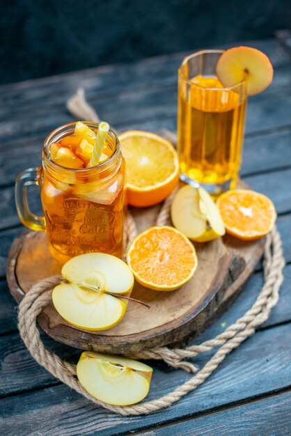 Vooraanzicht cocktail gesneden sinaasappelen en appels op een houten bord op dark