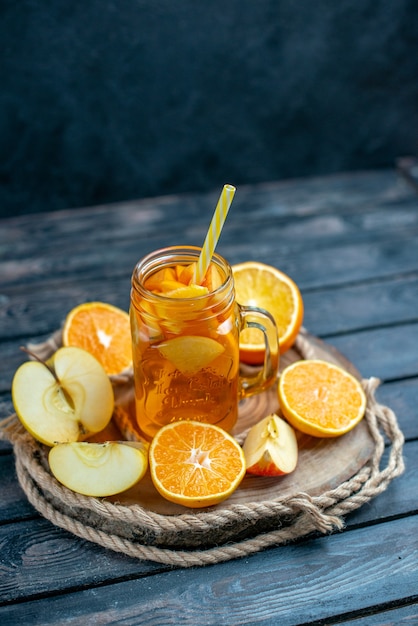 Vooraanzicht cocktail gesneden sinaasappelen en appels op een houten bord op donkere geïsoleerde achtergrond