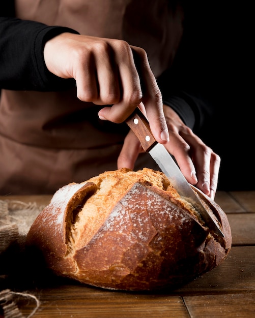 Vooraanzicht dat van chef-kok heerlijk brood snijdt