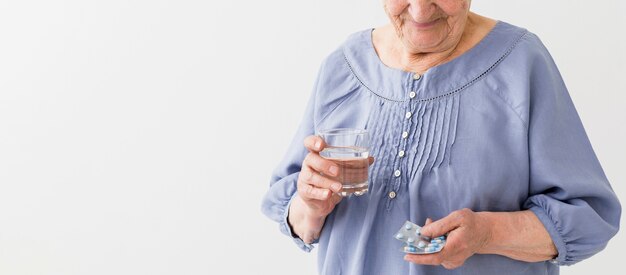 Vooraanzicht dat van oudere vrouw haar pillen met exemplaarruimte neemt