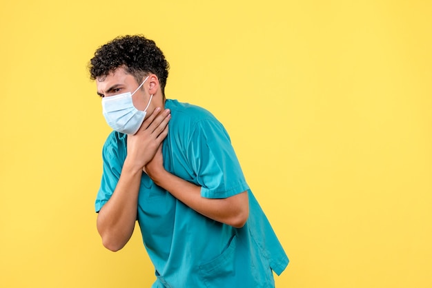 Vooraanzicht dokter de dokter in masker heeft een hoest