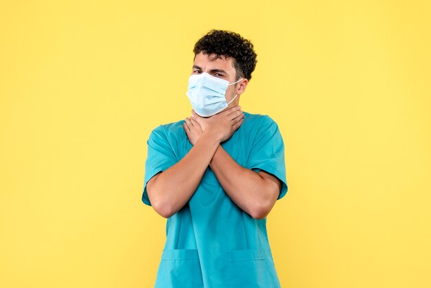 Vooraanzicht dokter de dokter met masker zegt dat je een ambulance moet bellen als je keelpijn hebt