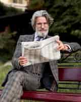 Gratis foto vooraanzicht elegante senior mannelijke krant lezen