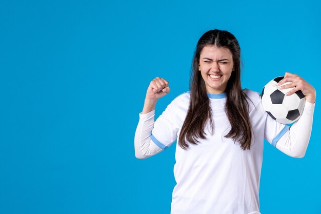 Vooraanzicht emotionele jonge vrouw met voetbal