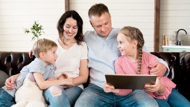 Vooraanzicht en gelukkige familie met apparaat