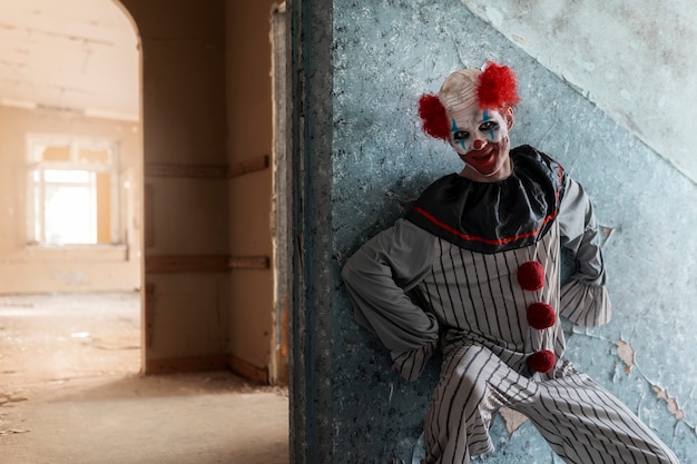 Vooraanzicht enge clown in verlaten gebouw