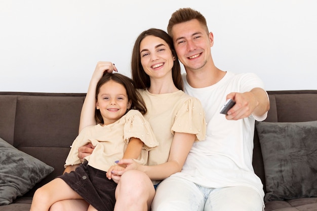 Vooraanzicht familie zittend op de bank kijken naar de tv