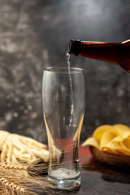 Vooraanzicht fles beer gieten in het glas op lichte achtergrond