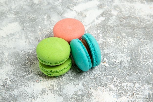 Vooraanzicht franse macarons kleurrijke taarten op de witte oppervlakte taart taart bakken koekje zoet koekje