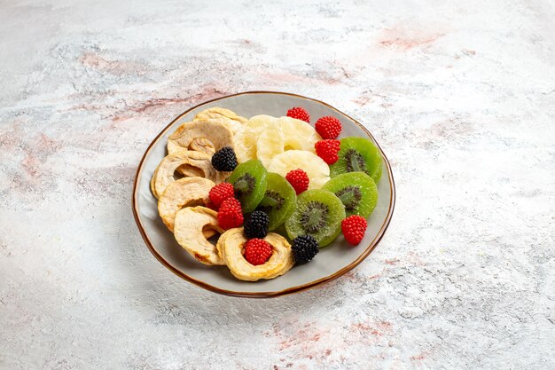 Vooraanzicht gedroogde ananas ringen met gedroogde kiwi's confitures en appels op wit oppervlak fruit droge zoete kandijsuiker