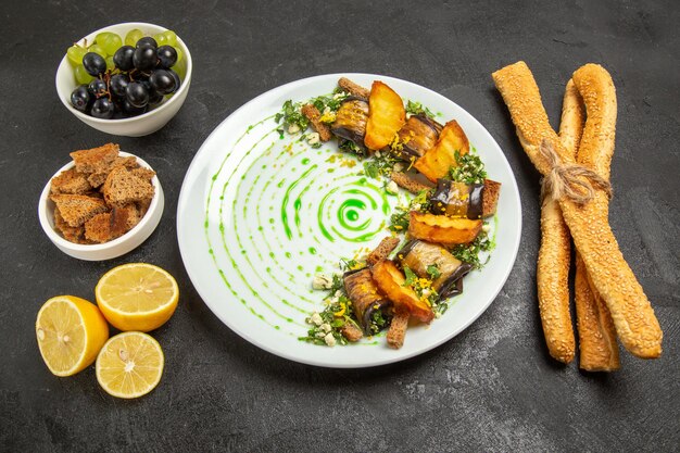 Vooraanzicht gekookte auberginebroodjes met druiven en citroenplakken op donkere achtergrondschotel dinermaaltijd fruit koken