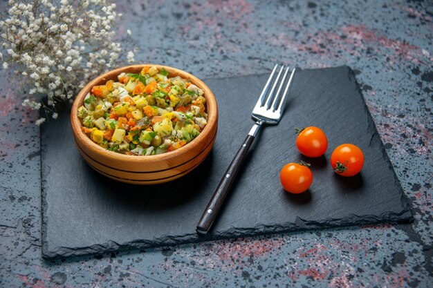 Vooraanzicht gekookte groentesalade met vork op blauwe achtergrond