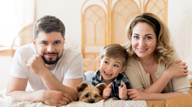 Vooraanzicht gelukkige familie en hun schattige hond