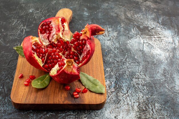 Vooraanzicht gesneden granaatappels vers rood fruit op de lichte tafel fruit rood vers