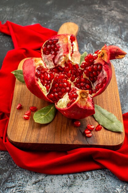 Vooraanzicht gesneden granaatappels vers rood fruit op licht-donker bureau fruit rood vers