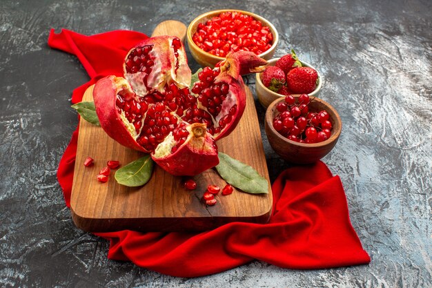 Vooraanzicht gesneden granaatappels vers rood fruit op licht-donkere tafel rode bes vers