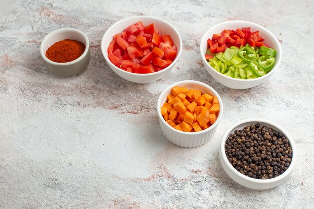 Vooraanzicht gesneden groenten met paprika op het witte oppervlak