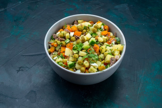 Vooraanzicht gesneden groentesalade gepeperd met kippenplakken binnen plaat op de donkerblauwe bureausalade plantaardige maaltijd snack lunch