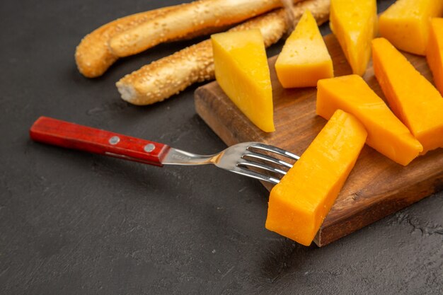 Vooraanzicht gesneden verse kaas met broodjes op donkere kleurenfoto snackmaaltijd ontbijt knapperig