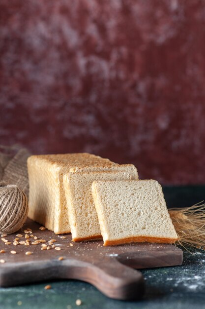 Vooraanzicht gesneden wit brood op donkere achtergrond broodje deeg bakkerij thee ochtend gebak eten ontbijt brood