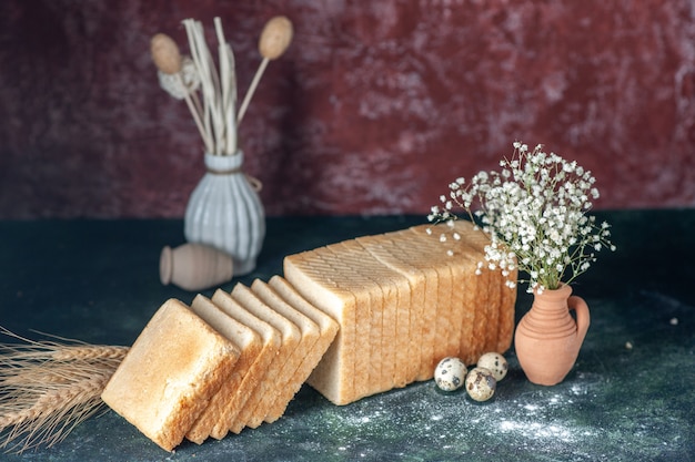 Vooraanzicht gesneden wit brood op donkere achtergrond thee ontbijt eten deeg gebak broodje ochtend brood bakkerij