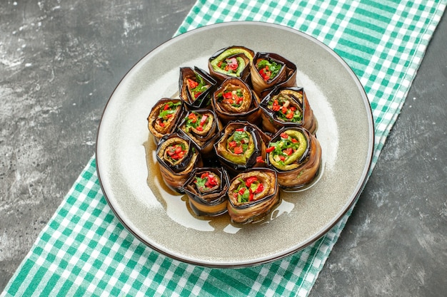 Gratis foto vooraanzicht gevulde auberginebroodjes in wit ovaal bord turquoise-wit tafelkleed op grijze achtergrondcloth