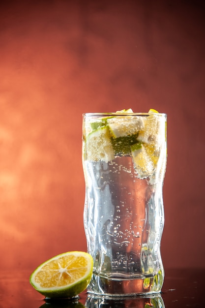 Vooraanzicht glas frisdrank met schijfjes citroen op lichtroze foto champagne water cocktail drinken limonade