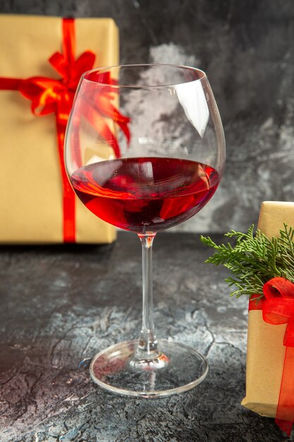 Vooraanzicht glas wijn geschenken op donkere achtergrond